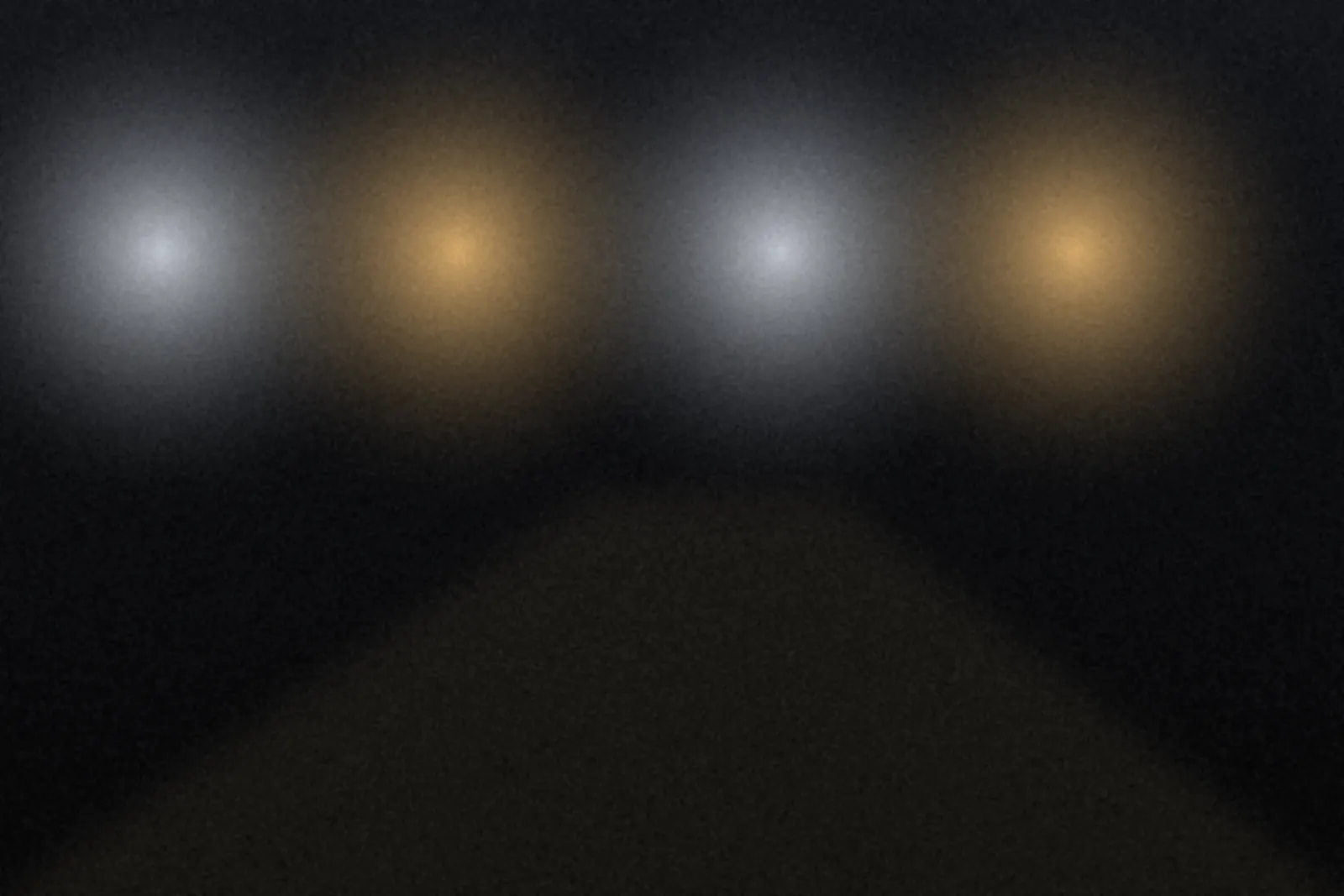 Street lamps glowing over a dark road